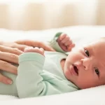 Home 8 Recém-nascido com soluço sendo confortado pela mãe em ambiente calmo